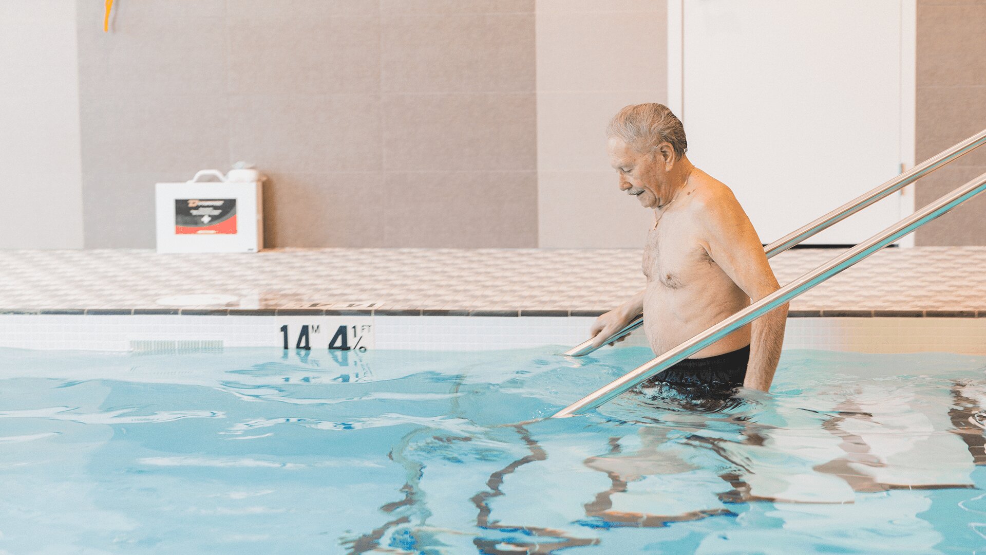 Activities for seniors, elderly man swimming in pool in senior living