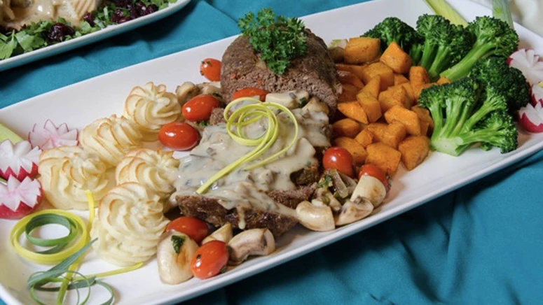 Plate of food including vegetables, meat, and garnishing. Healthy meals for seniors.
